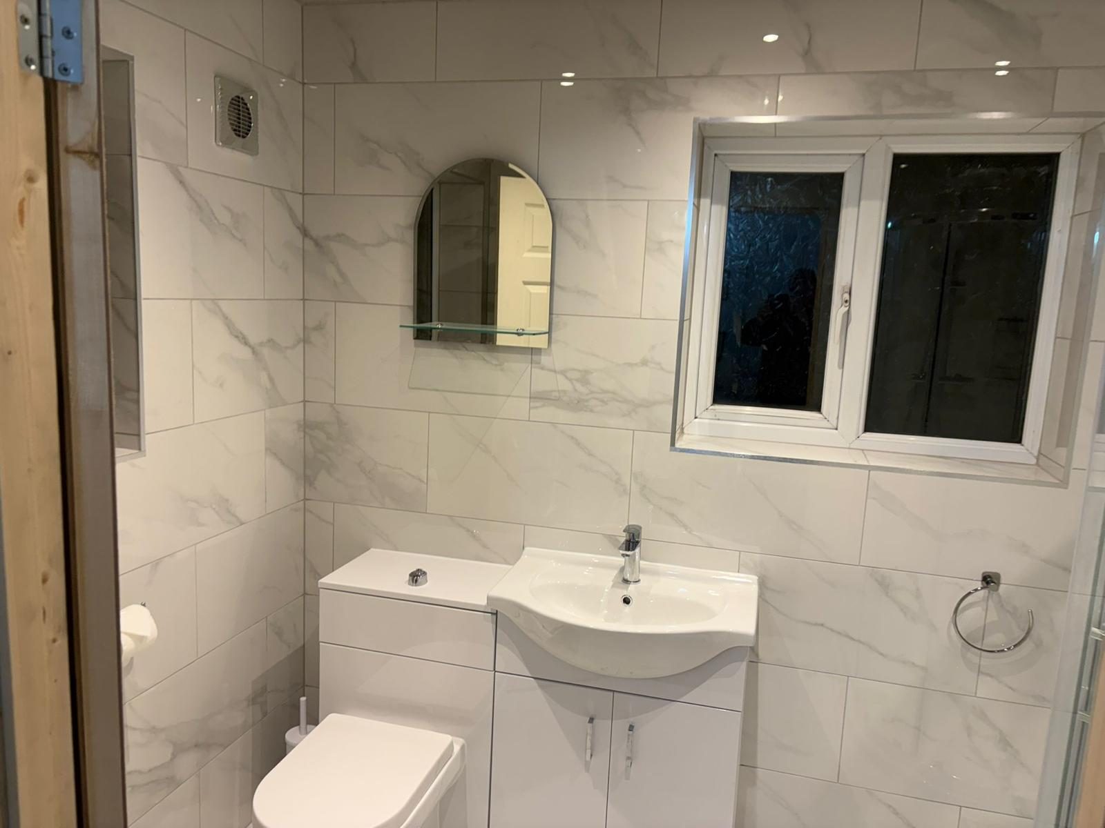 Tiled bathroom with vanity, toilet, mirror and towel ring fitted in South Wales