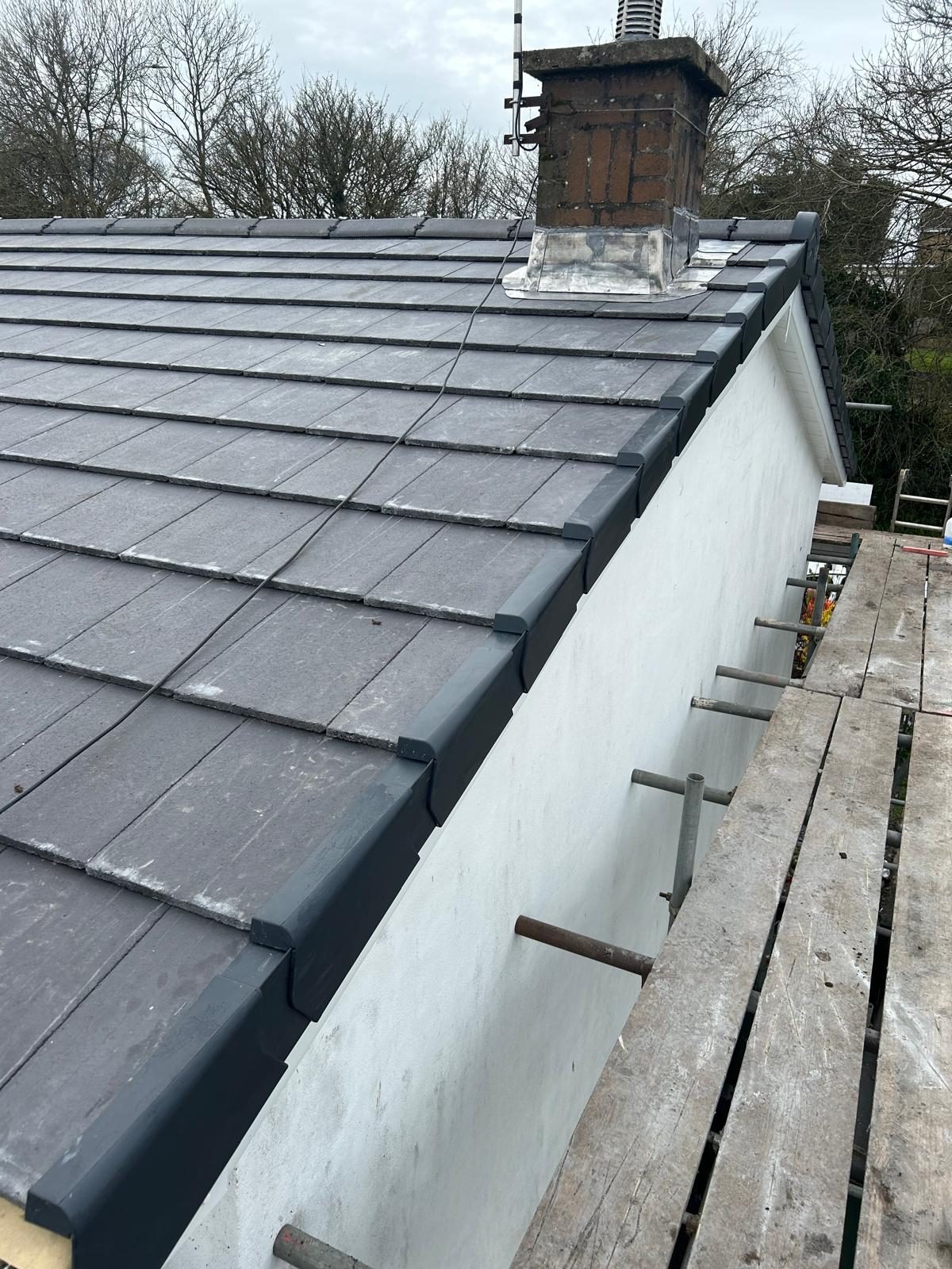 New grey tiled roof with fresh chimney flashing completed by MB Construction in South Wales