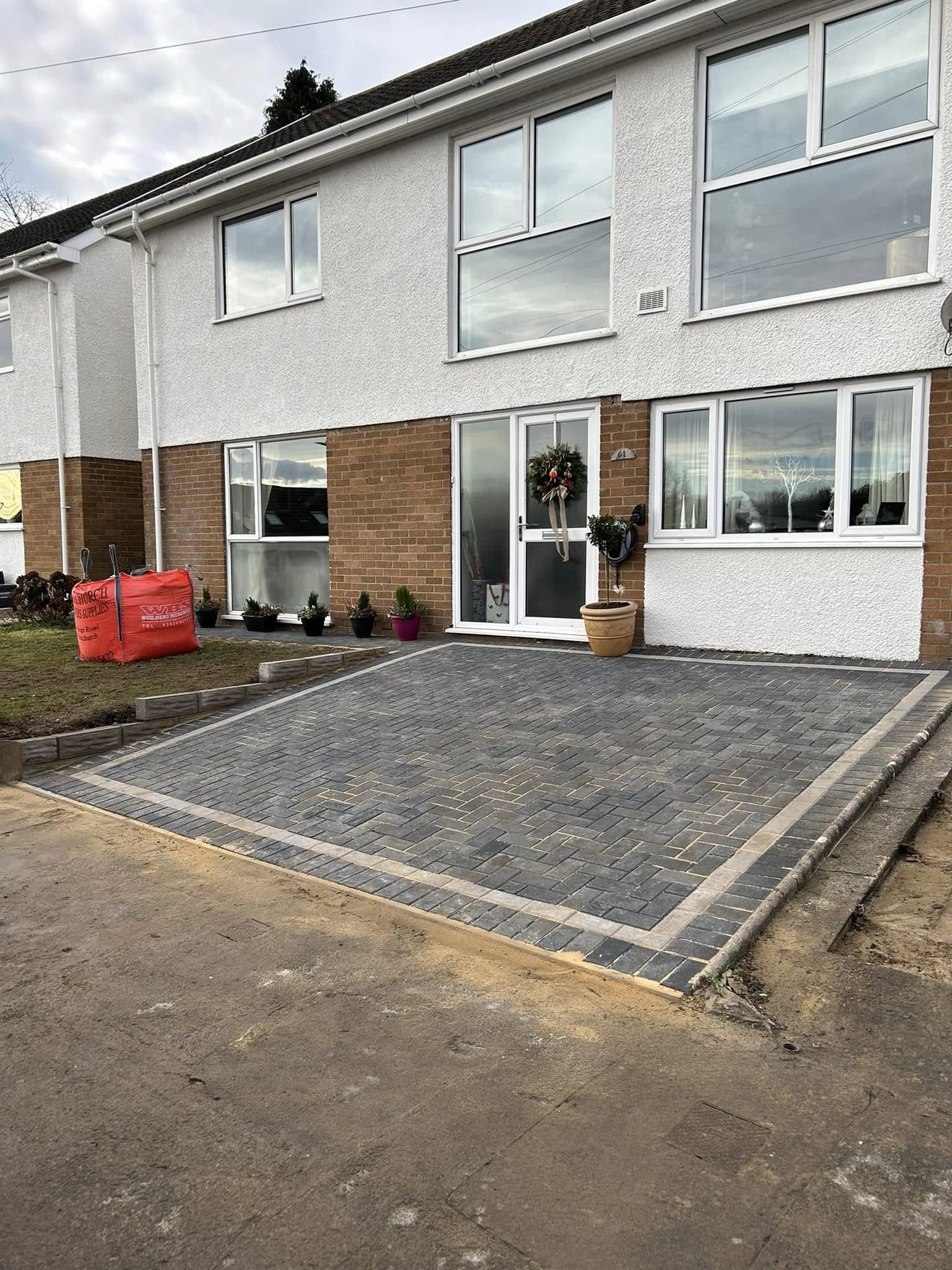 New charcoal block paved driveway with contrasting border after installation