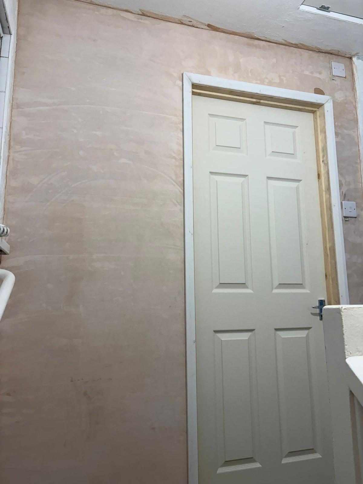 Freshly plastered room with a new white internal door hung ready for decorating