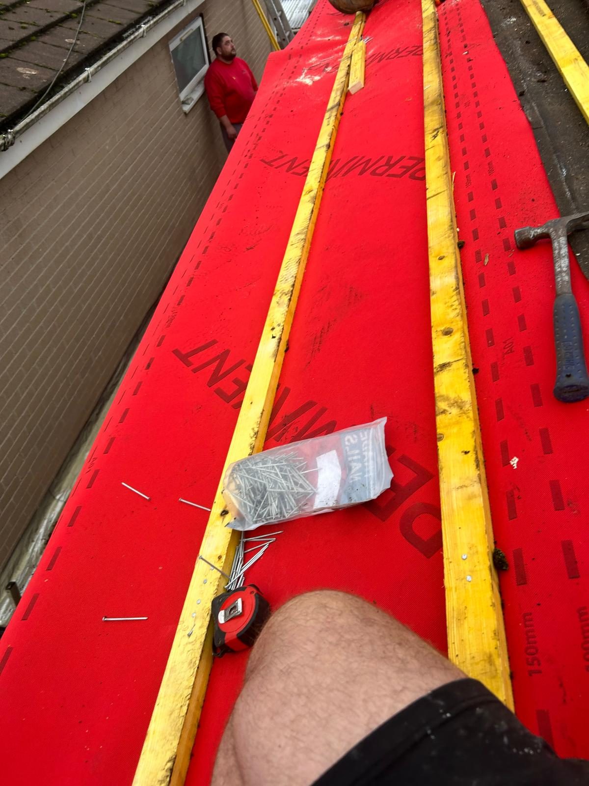 Re-roof in progress with red breathable roofing membrane and timber battens being fixed