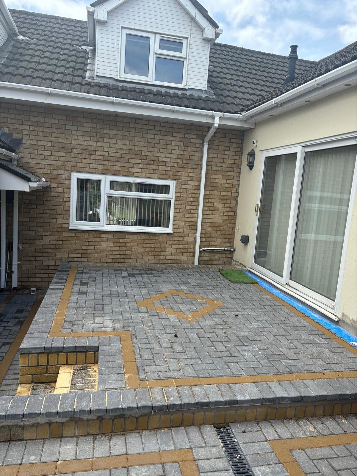 New patterned block paved patio with buff border and feature detail