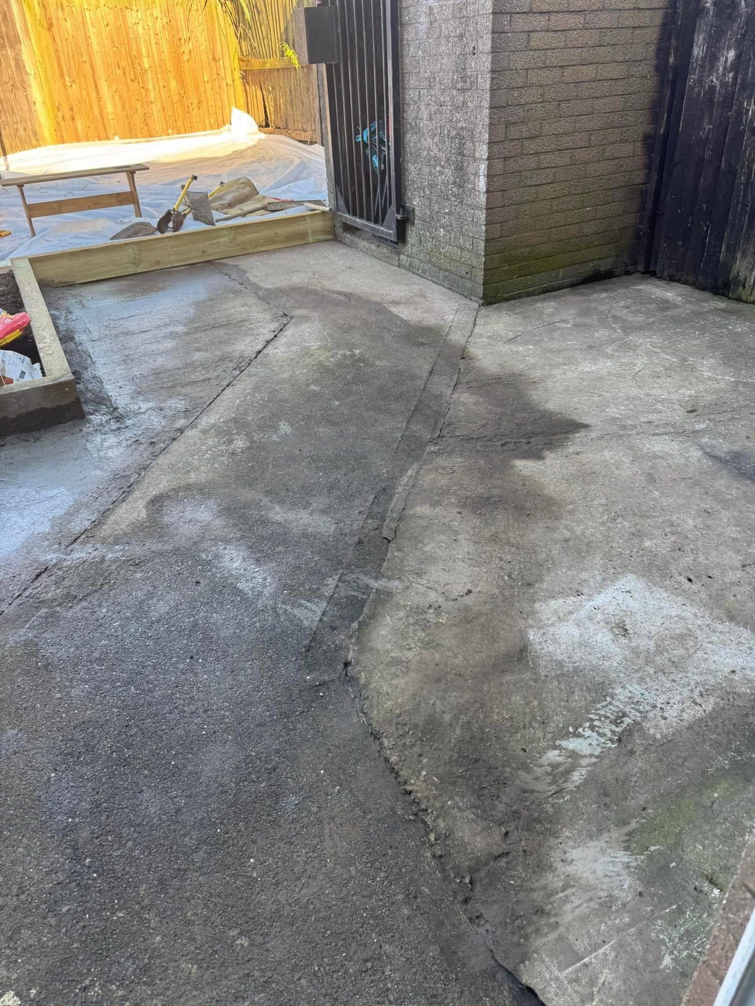 Worn patched concrete side passage before resin bound surfacing