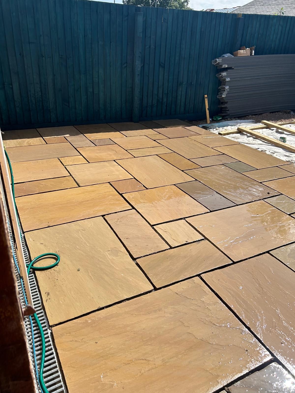 Indian sandstone patio slabs being laid in a South Wales rear garden